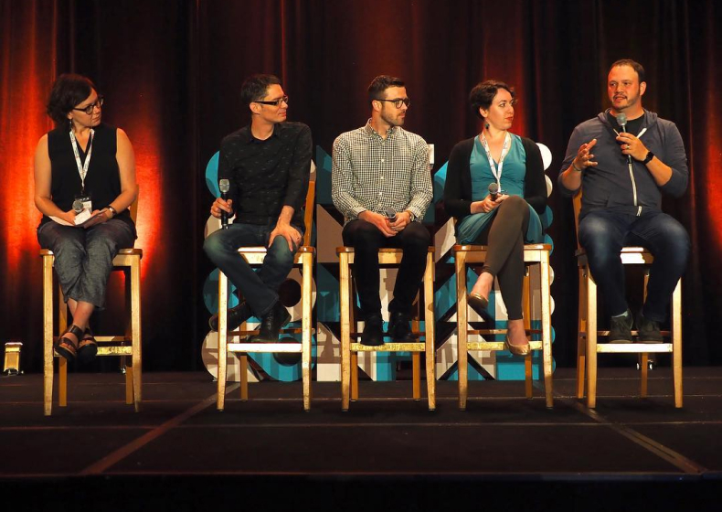 Photo of confab panel speaking to attendees.