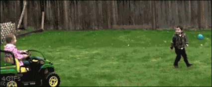 child driving a motorized toy car and running over another child